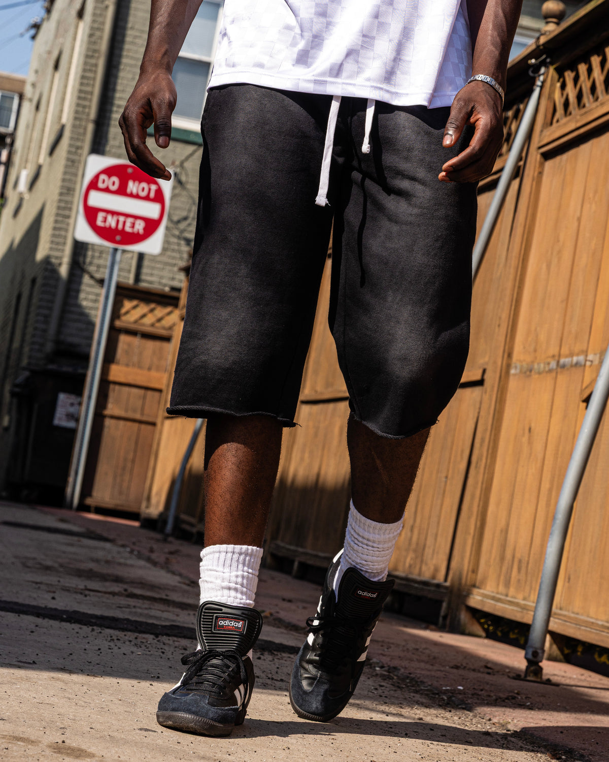 PRVT LBL styling with black shorts, a white tee and black sneakers outdoors