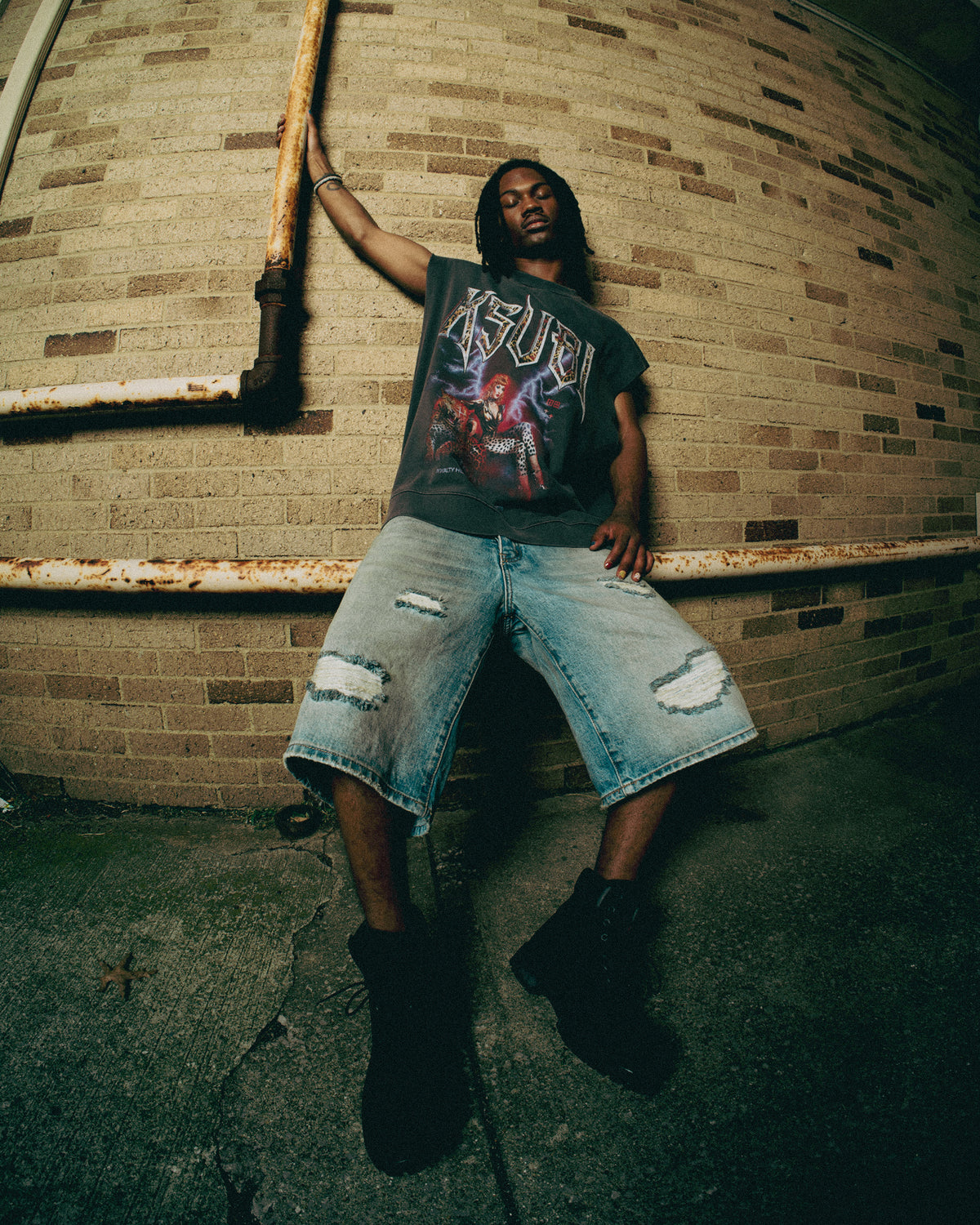 Streetwear styling with a graphic sleeveless tee and relaxed denim shorts