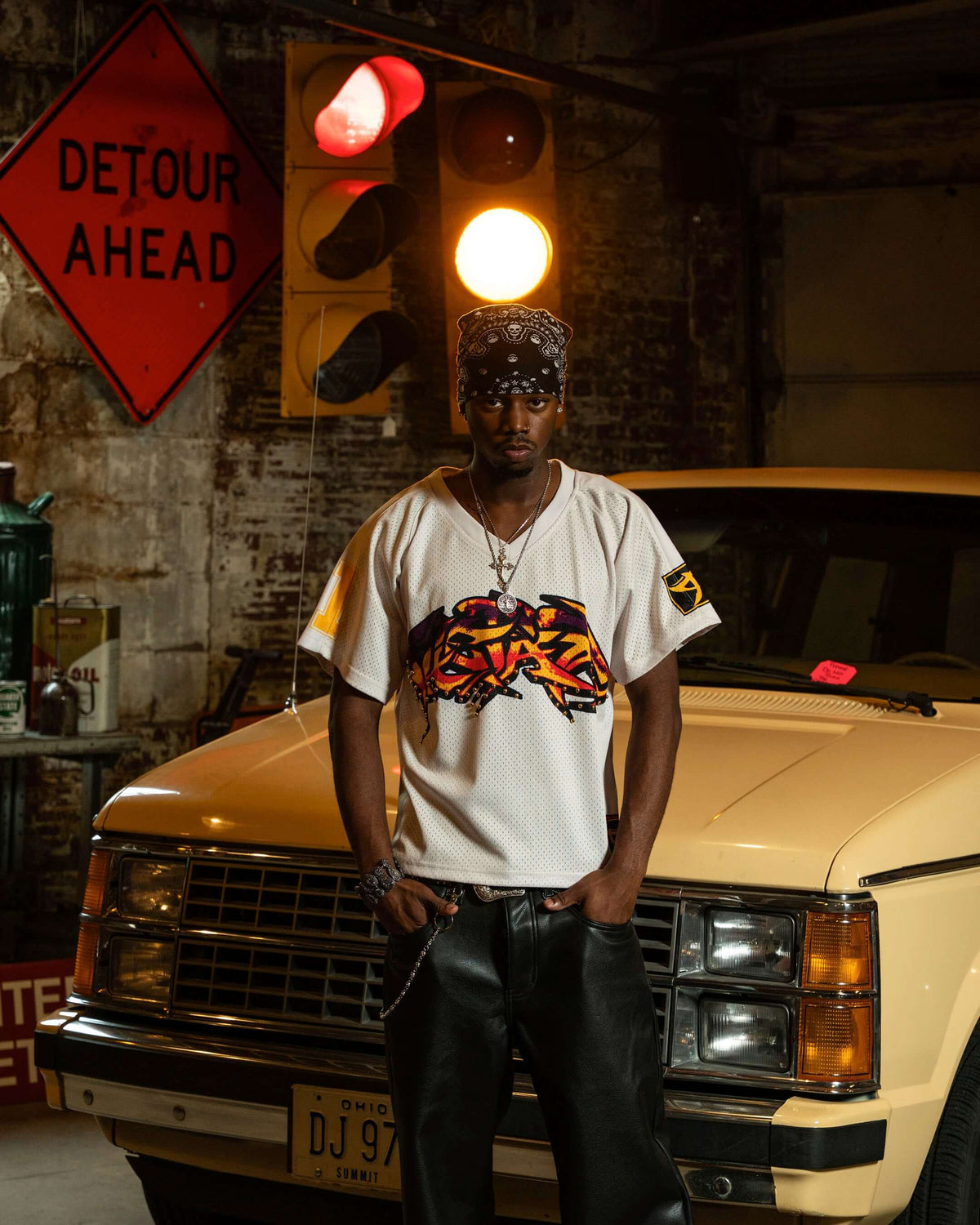 PRVT LBL campaign with a model in a graphic white jersey beside a gold car
